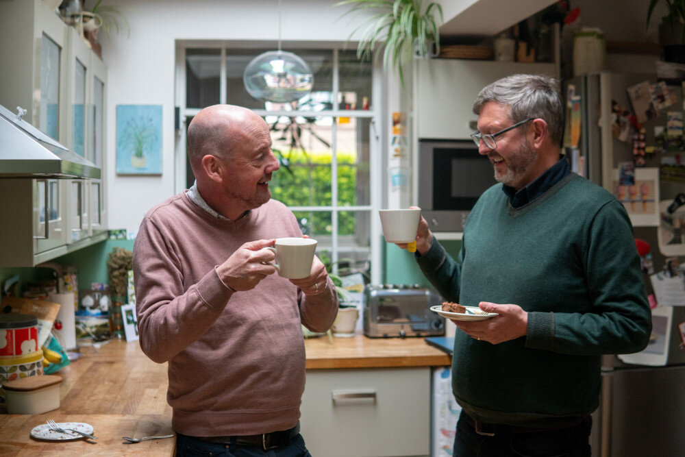 2 alte Freunde stehen in einer gemütlichen Wohnküche und trinken gemeinsam eine Tasse Tee.  | © centre-for-ageing-better-xikSJt7mr9E-unsplash