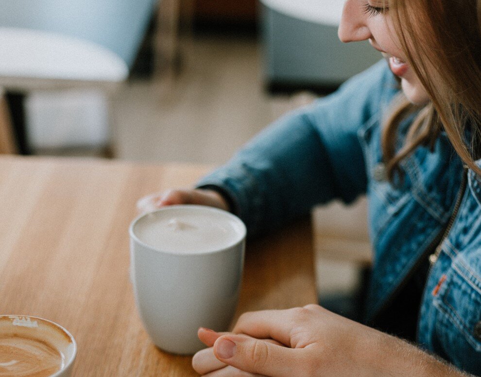 Ein verlobtes Paar sitzt im Café und hält sich an der Hand