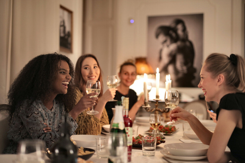 Freundinnen stoßen an einem reich gedeckten Dinnertisch mit Wein auf ihre Freundschaft an | © pexels-andrea-piacquadio-3937468
