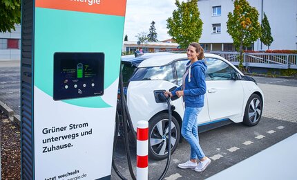 Frau tankt Strom für e-Auto