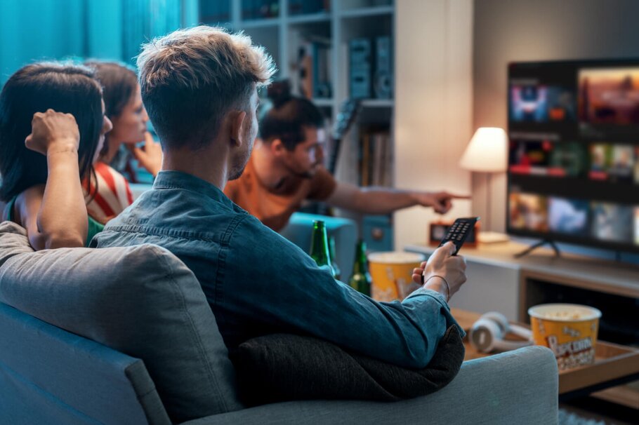 Gruppe junger Menschen streamt Videos auf Fernseher