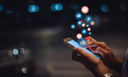 Person nutzt Social Media am Smartphone
