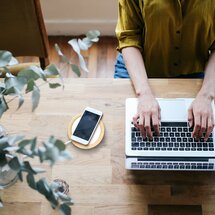 Pflanze, Finger, Mensch, Laptop, Smartphone, Handy, Tasse, Tisch, Holz, aufladen, kabelloses Laden Pflanze, Finger, Mensch, Laptop, Smartphone, Handy, Tasse, Tisch, Holz, aufladen, kabelloses Laden